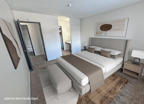 A bedroom with a large bed and a mirror on the wall.