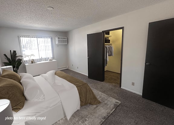 A bedroom with a bed, a wardrobe, and a window.