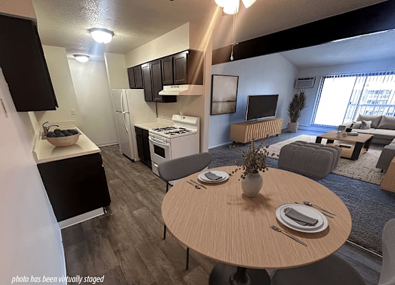 A modern kitchen with a dining table set for two.