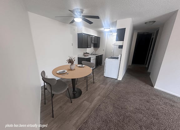 A small, modern kitchen with a dining table and chairs.