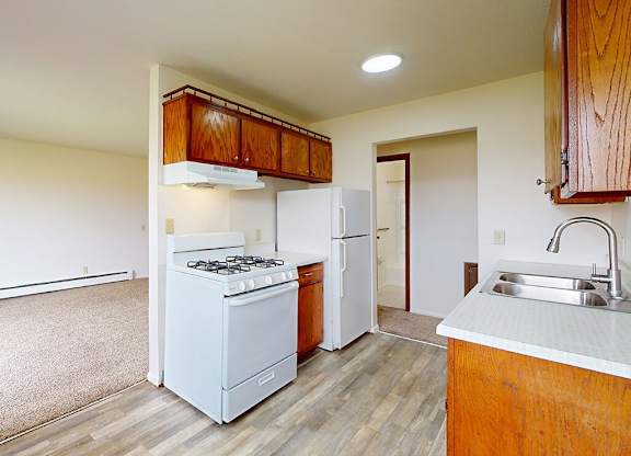 A kitchen with a white stove and a white refrigerator.