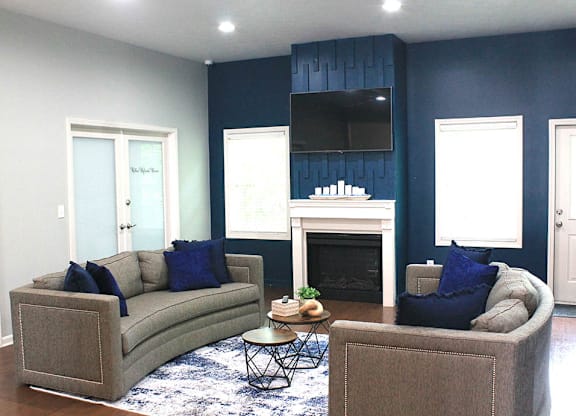 a living room with blue walls and a fireplace with a tv above it