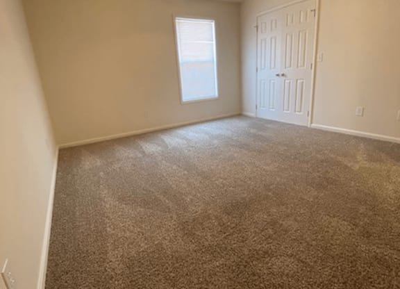 spacious bedroom with connected closet and window