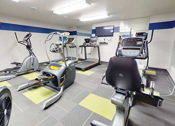 Cardio exercise equipment including treadmills and stationary bikes at The Chateau Apartments