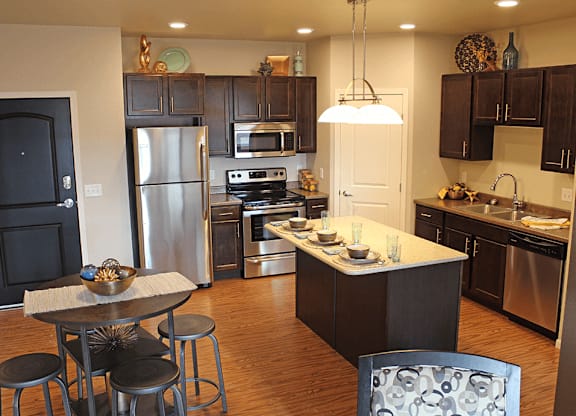 apartment kitchen with stainless steel appliances and a large island with a breakfast bar