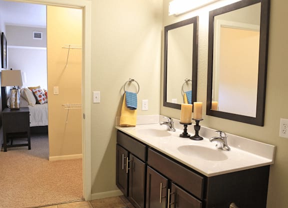 a bathroom with two sinks and two mirrors