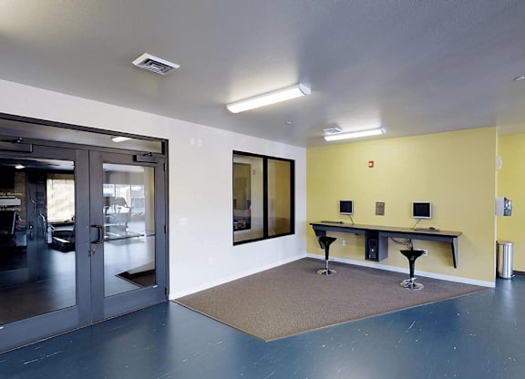 a room with a door and two tables with stools