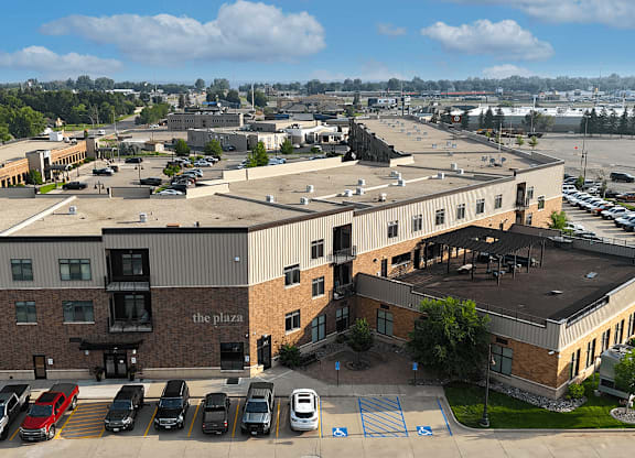 A parking lot with cars and a building named "The Plaza".