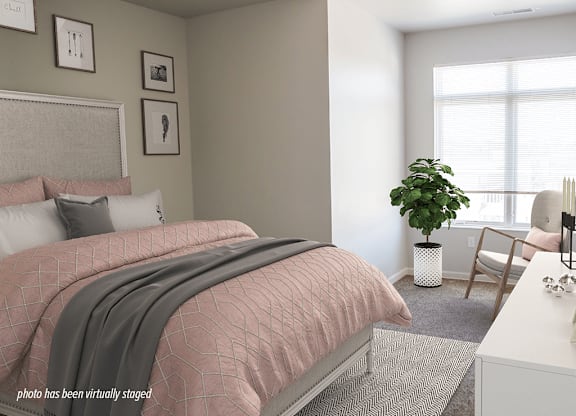 A bedroom with a pink bedspread and a grey blanket.