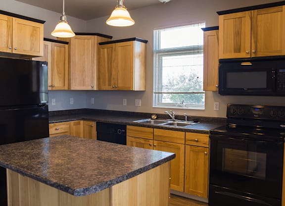 a kitchen with wooden cabinets and black appliances