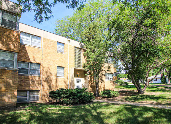 a large brick apartment building with trees in front of it