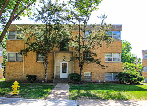 a brick building with a white door and a yellow fire hydrant in front of it