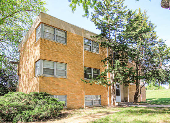 a brick building with trees in front of it