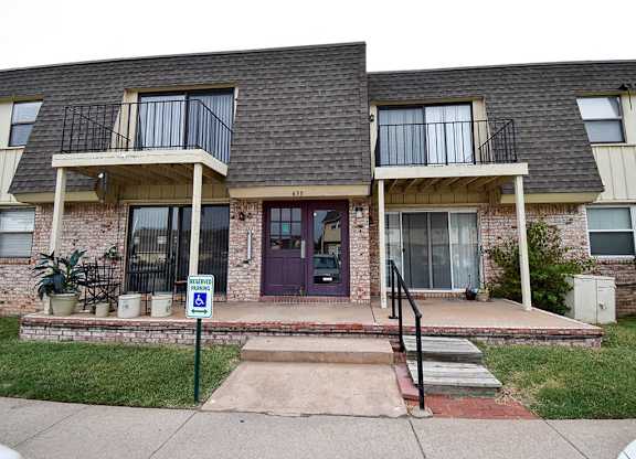 the front of a brick house with a purple door