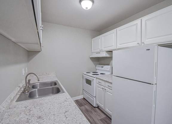A small kitchen with white appliances and cabinets.