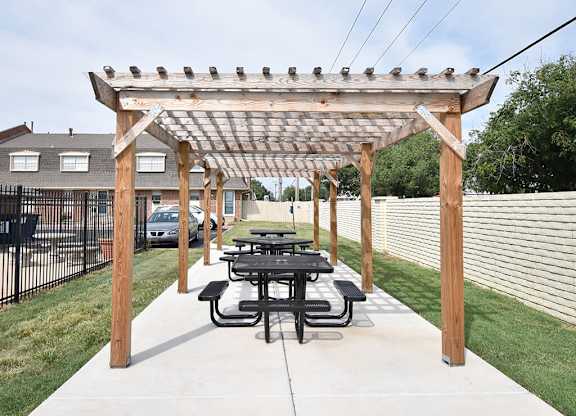 A wooden pergola with a picnic table underneath it.