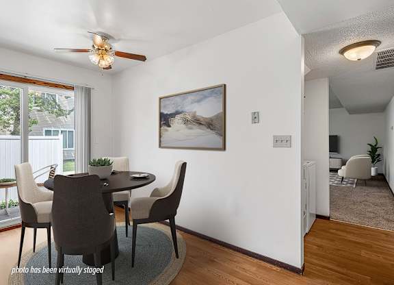 A dining room with a table and chairs.