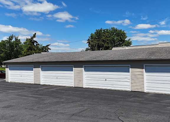 A row of closed garage doors in front of a building.