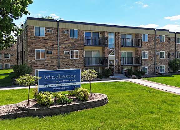 A large brick building with a sign that says Winchester in front of it.
