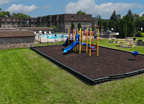 A playground with a blue slide and a red ball.