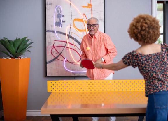 A man and a woman are playing a game with a red ball.