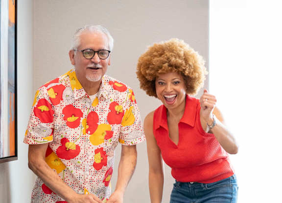 A man and a woman are playing a game of air hockey.