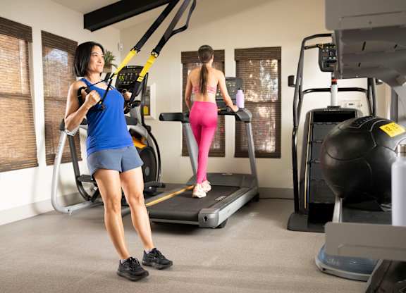 Two women exercising in a gym.
