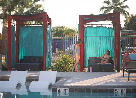 A woman in a bikini stands by a pool.