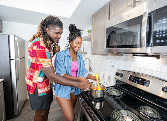 Two people cooking in a modern kitchen.