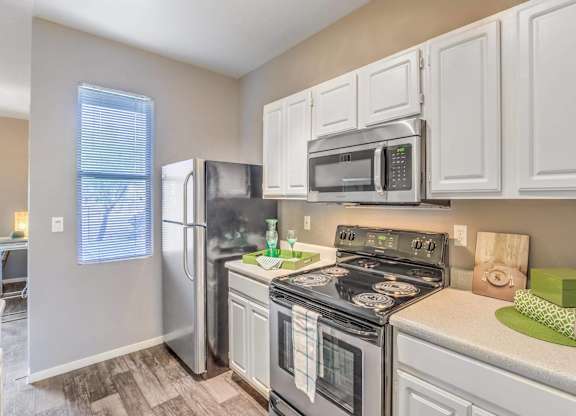 A kitchen with a stove, oven, refrigerator, and microwave.