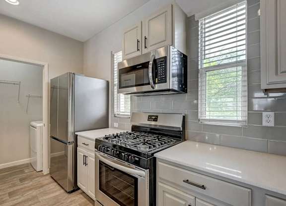 A kitchen with a stove top oven and a refrigerator. at Habitat @ DTLV, Las Vegas, 89106
