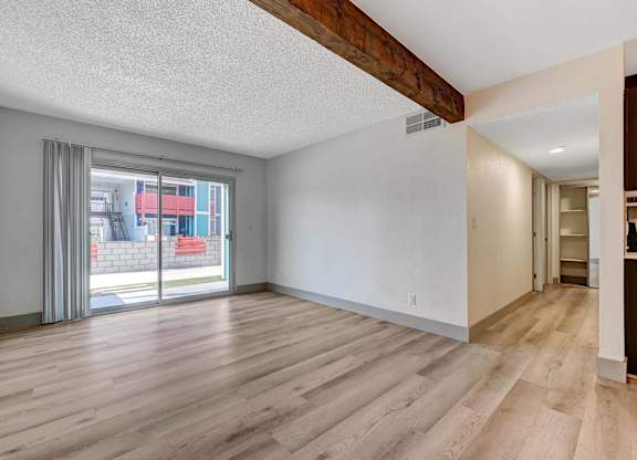A room with wooden flooring and a sliding glass door.