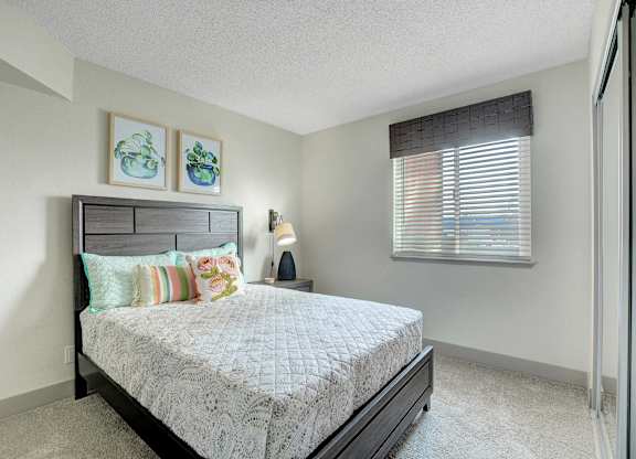 A bedroom with a bed, pillows, and a nightstand.