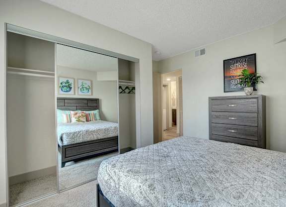A bedroom with a large bed and a smaller bed in the background.