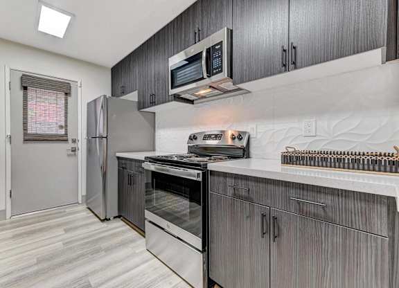 A modern kitchen with a stainless steel refrigerator and oven.