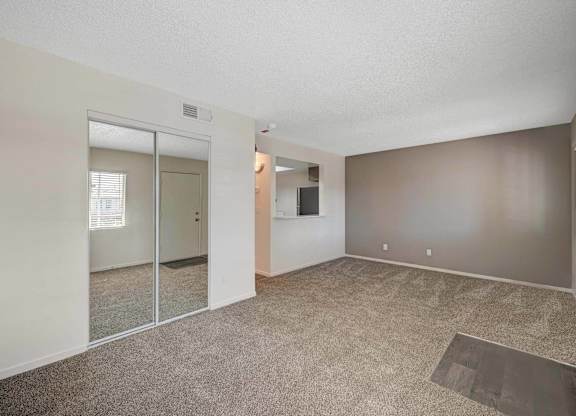 A room with a carpeted floor and a sliding glass door.