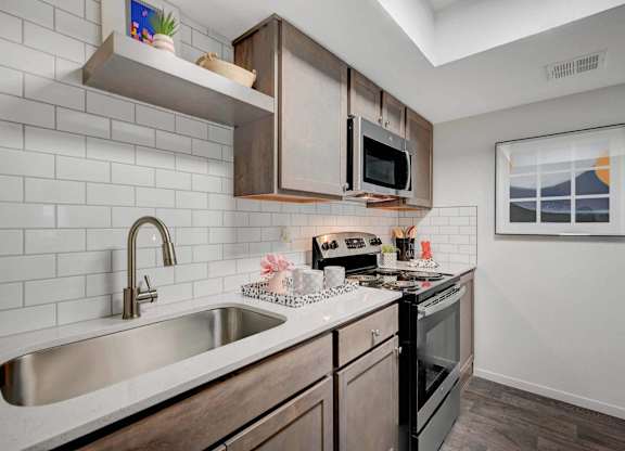 A kitchen with a white sink and black oven.
