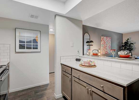 A kitchen with a white counter top and wooden cabinets.