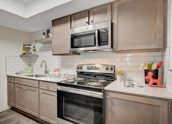 A modern kitchen with a stove, oven, and microwave.