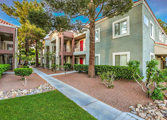 A row of houses with a tree in front of them.