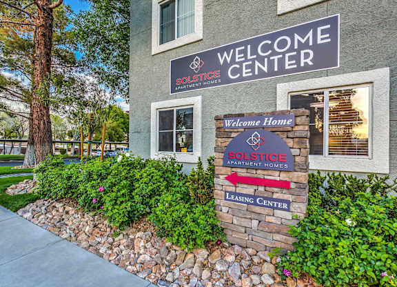 A building with a sign that says "Welcome Center" and "SOLSTICE APARTMENT HOMES".