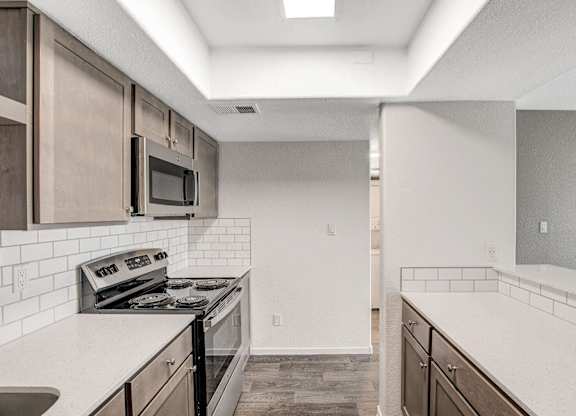 A kitchen with a stove, microwave, and oven. at The 95 Apartments, Las Vegas, NV