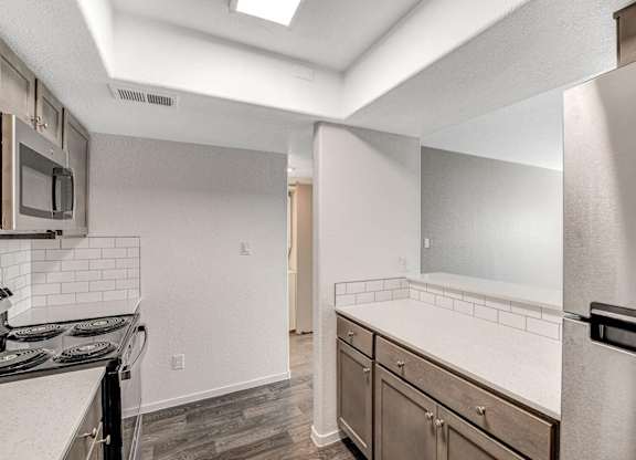 A kitchen with a stove top oven and a refrigerator. at The 95 Apartments, Nevada, 89129