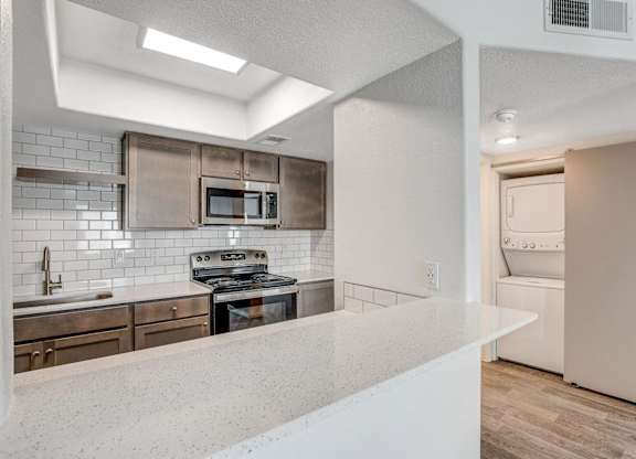 A modern kitchen with a white countertop and a stainless steel oven. at The 95 Apartments, Las Vegas, NV
