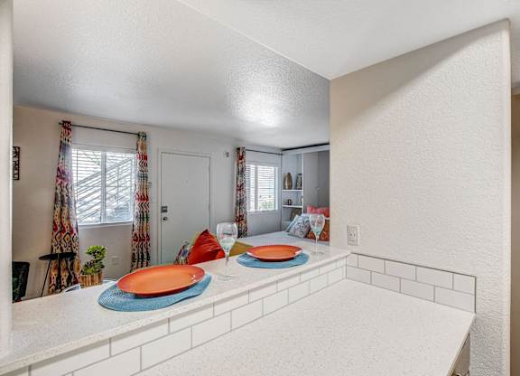 A kitchen with a white counter and a window with curtains. at The 95 Apartments, Las Vegas, Nevada