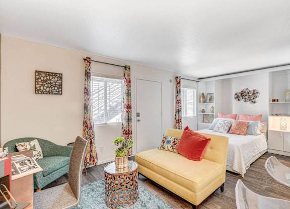 A living room with a yellow sofa and a coffee table. at The 95 Apartments, Nevada