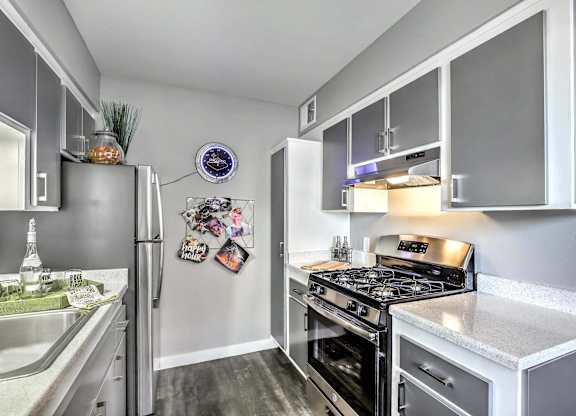A modern kitchen with a stainless steel refrigerator and a stove top oven.
