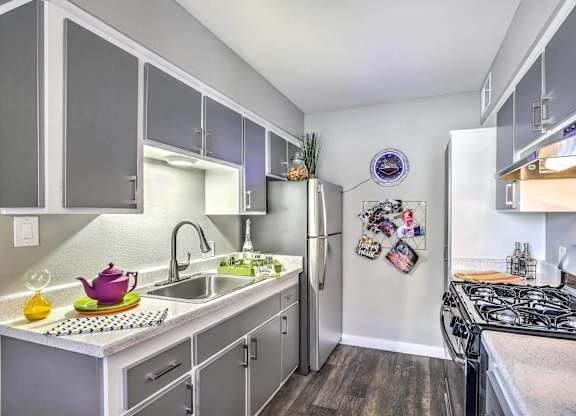 A kitchen with a white fridge and a black stove top.
