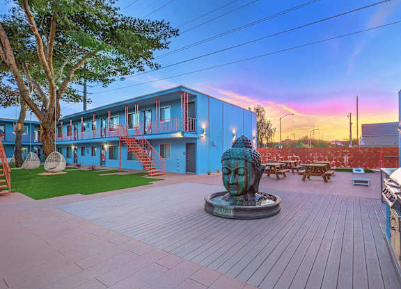 A statue of a face sits in the middle of a courtyard.