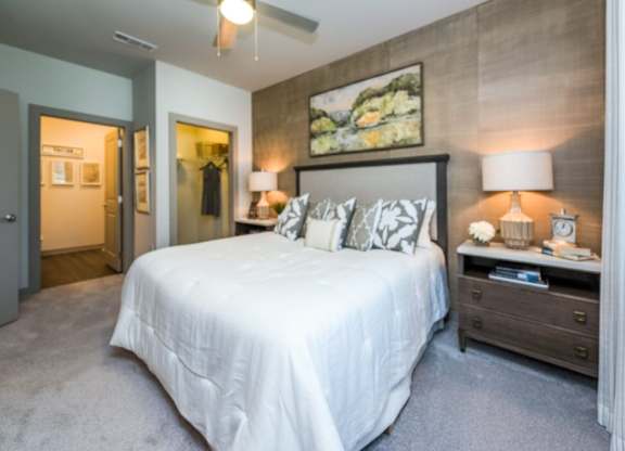 A bedroom with a large bed and a painting on the wall.